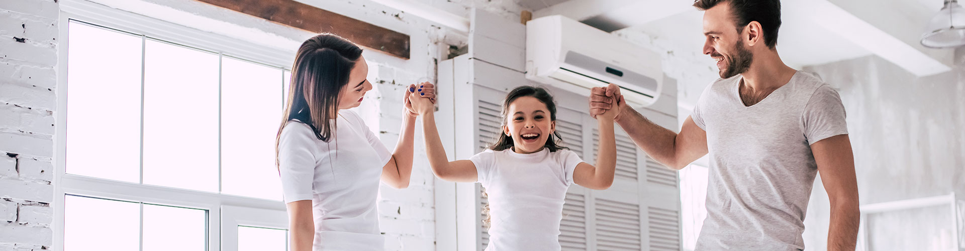 Family holding hands and smiling in a bright room with clean air from an Air Purifier Sponge system