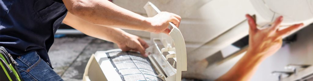 Technician opening an air conditioning unit to check the air filter for common cooling problems