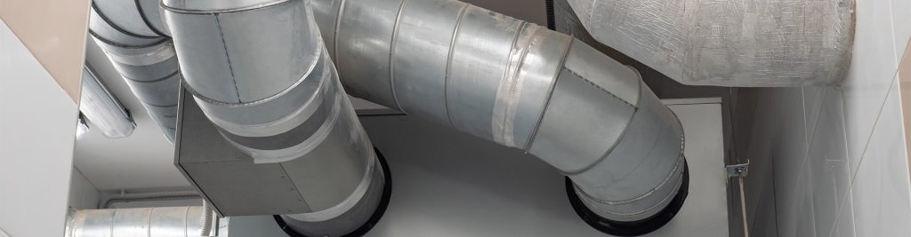 Close-up of ducted air conditioning pipework with metal ducts and joint connectors in a ceiling cavity