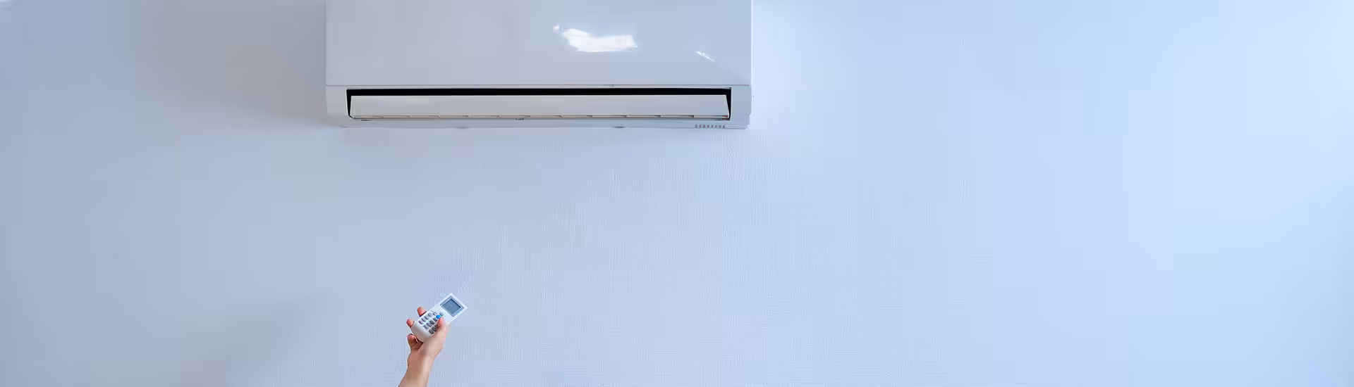 Wall-mounted split air conditioning unit being controlled with a white remote, comparing Daikin vs. Fujitsu systems