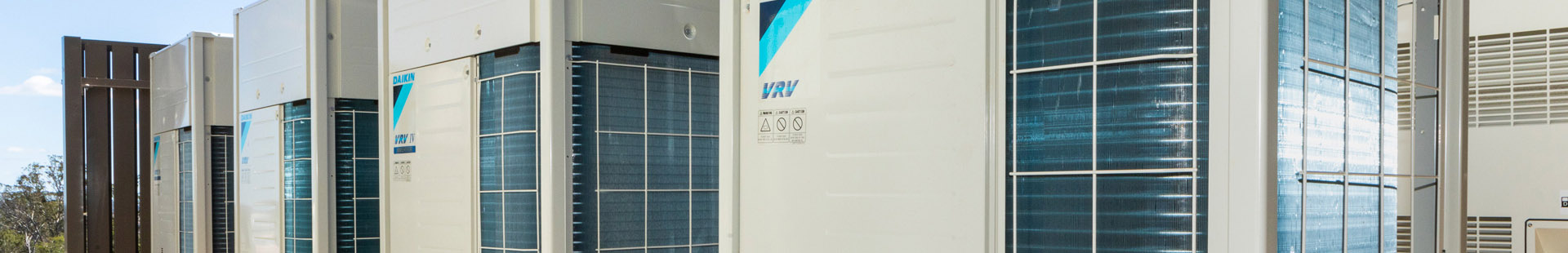 Row of Daikin VRV commercial air conditioning condenser units installed outside a building