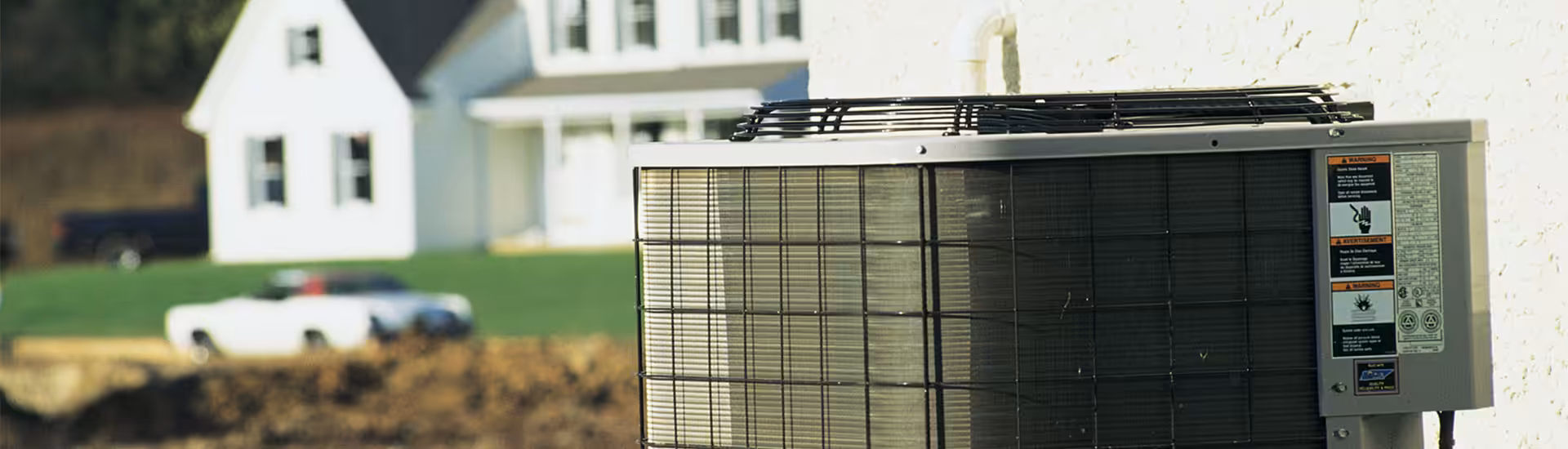 High-efficiency outdoor air conditioning condenser unit installed beside a house wall